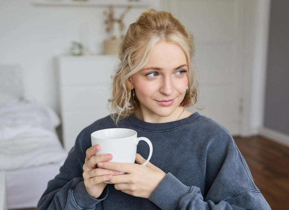 Frau entspannt lächelnd auf dem Sofa zu Hause